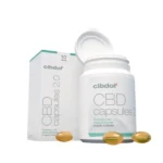 Une bouteille blanche et une boîte étiquetée « 5% CBD 2.0 softgels capsules - Cibdol » contiennent de nombreuses capsules dorées, avec la bouteille ouverte et plusieurs capsules affichées devant.