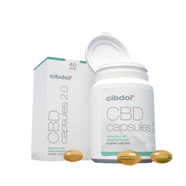 Un récipient ouvert de capsules molles Cibdol 5% CBD 2.0 révèle des capsules dorées, positionnées à côté de sa boîte d'emballage.