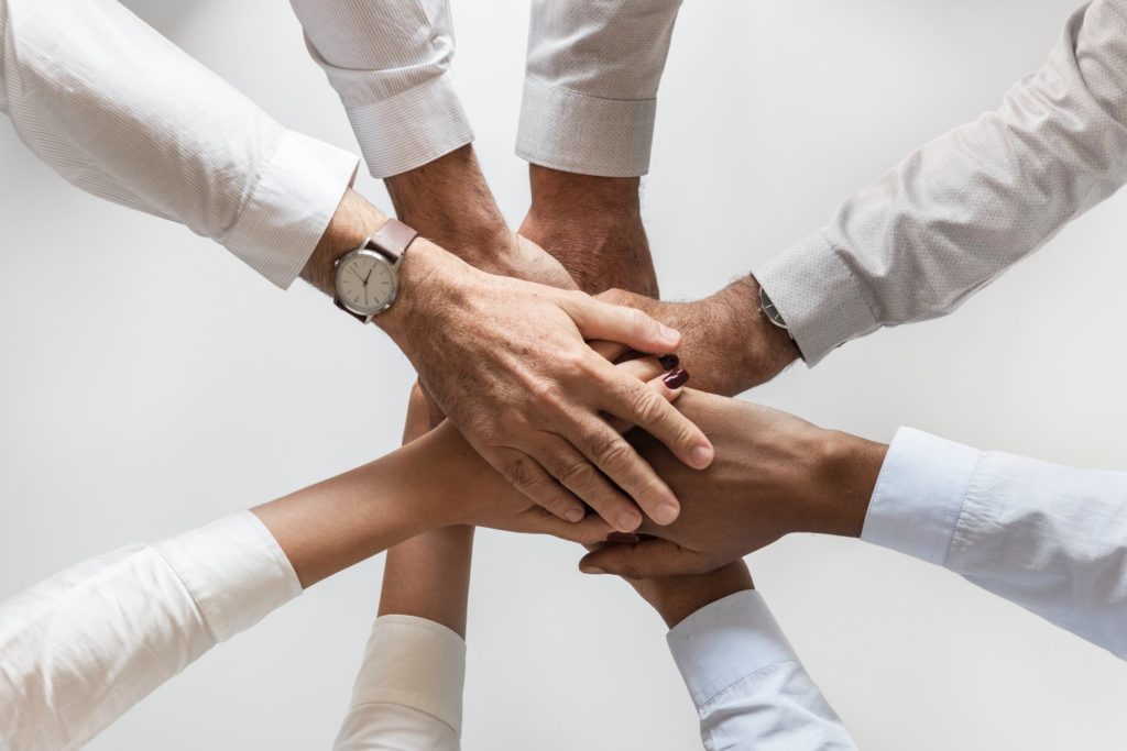 un groupe de personnes mettant leurs mains ensemble.