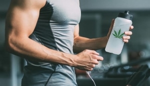 un homme tenant une bouteille d'eau avec une feuille de marijuana dessus.